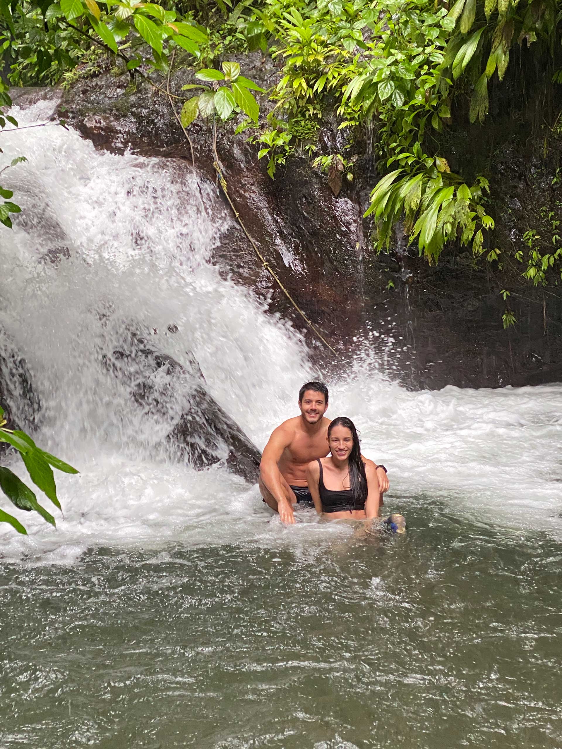 Riders cooling off by a waterfall on the Manuel Antonio ATV Tour